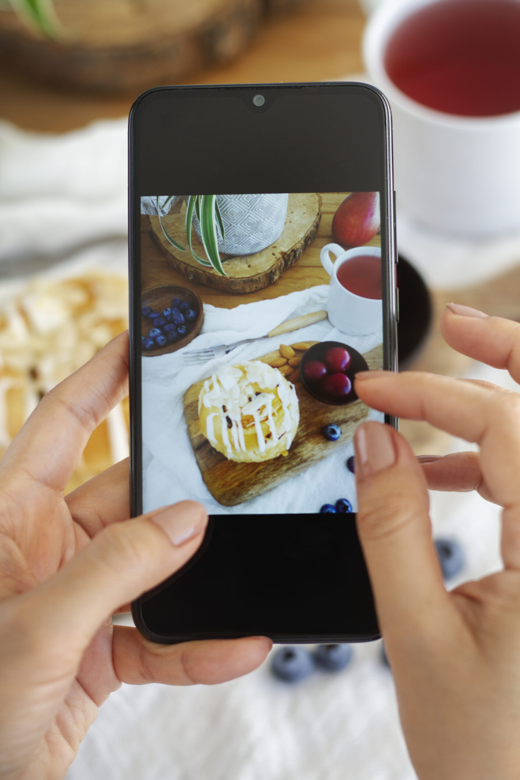 person-taking-photo-puff-pastry-tea-with-smartphone